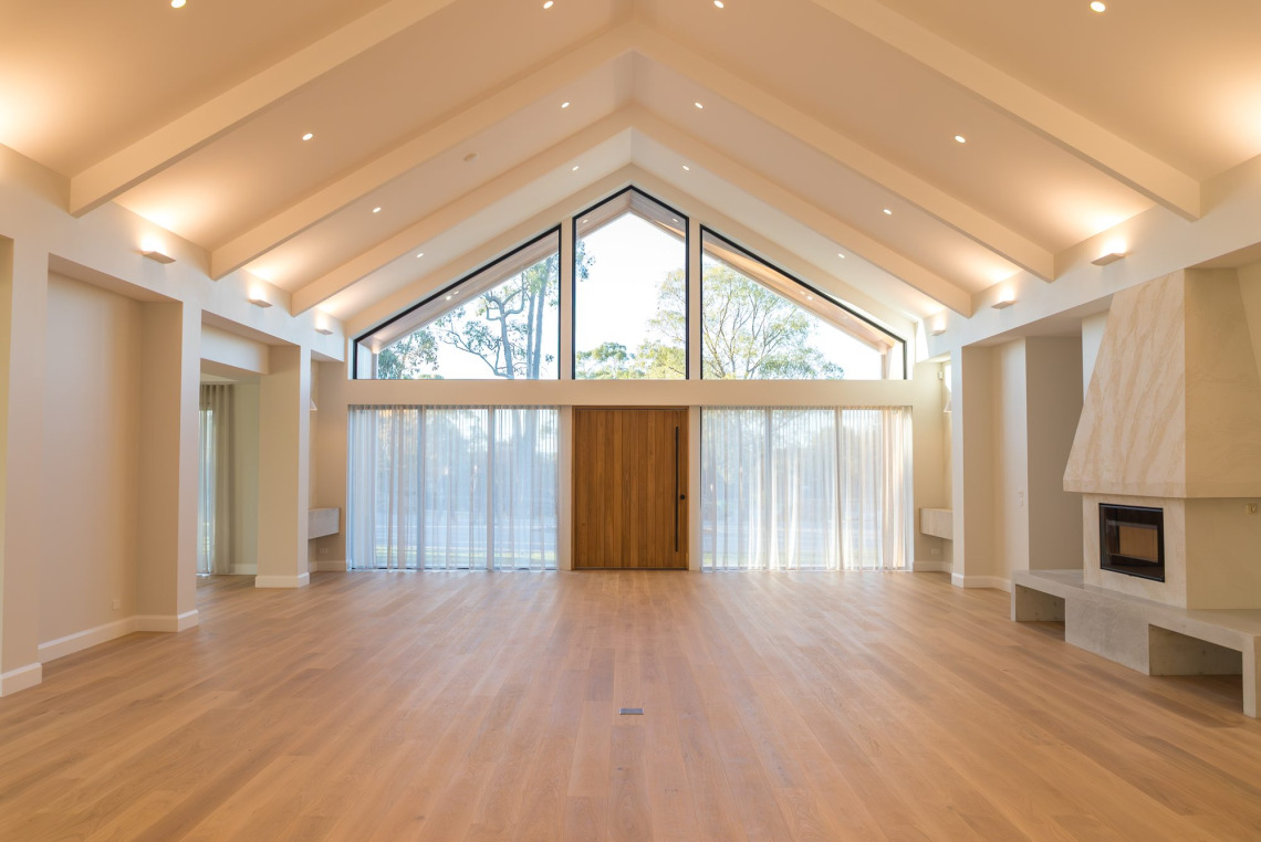 Vaulted living room with a full-height raked window gable above the timber front door