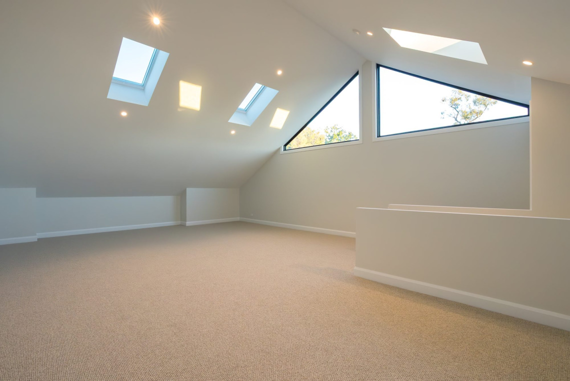 Loft room lit by triangular Signature raked windows and skylights