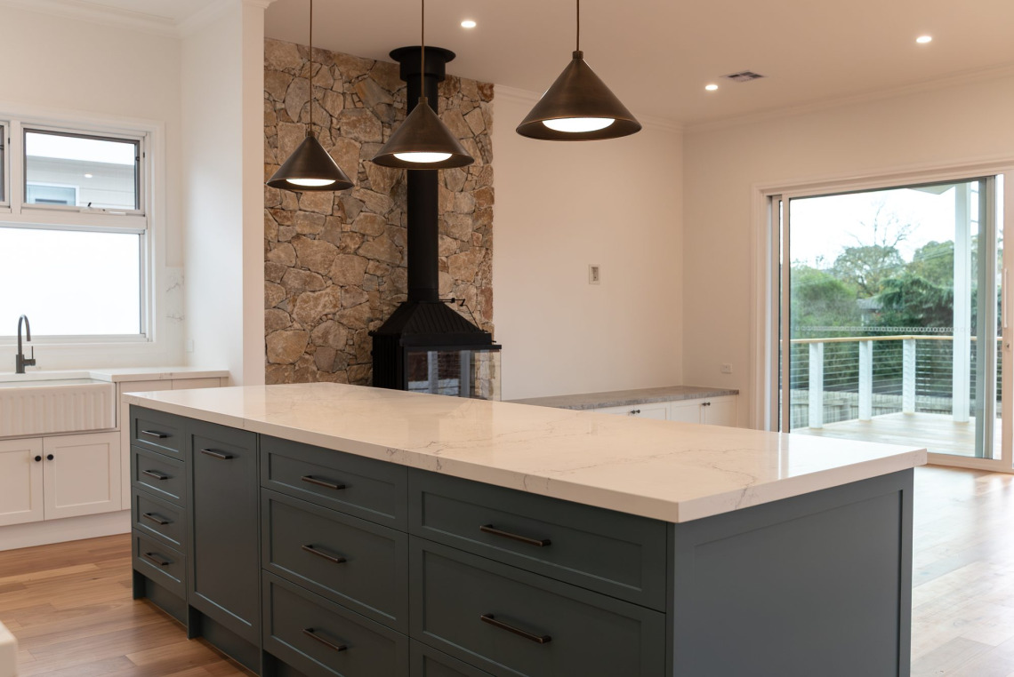 Kitchen island with awning window above the sink and aluminium stacking door to the deck, Ringwood North